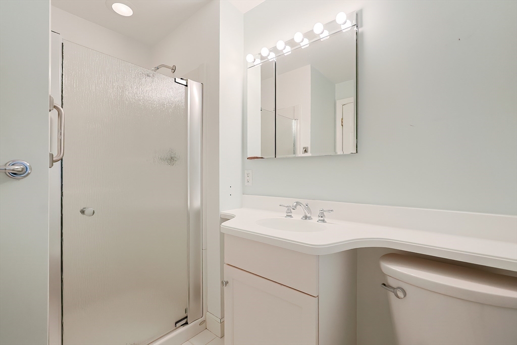 35 Windemere Road Wellesley, MA 02481 - Photo 8 of 24 a bathroom with a sink a shower a mirror and a shower
