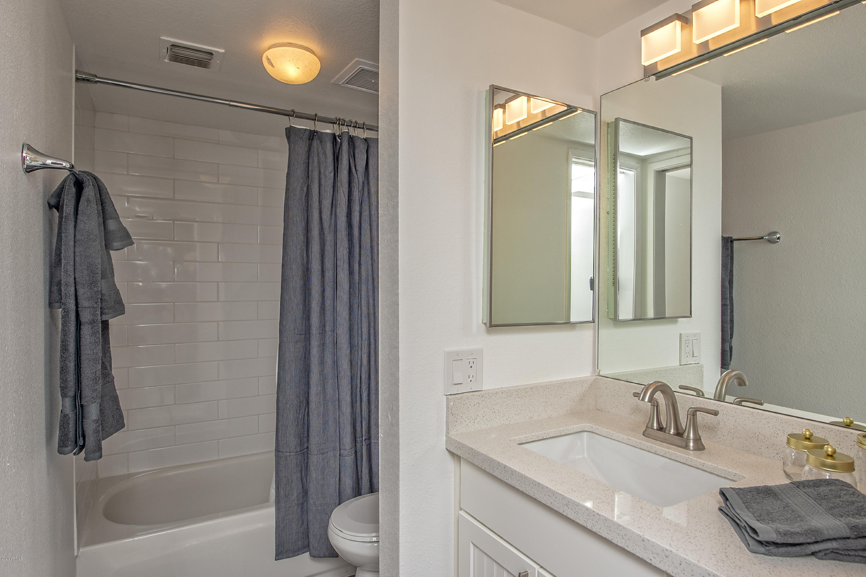 5209 North 24th Street, Unit 103 Phoenix, AZ 85016 - Photo 13 of 17 a bathroom with a granite countertop sink a toilet and shower