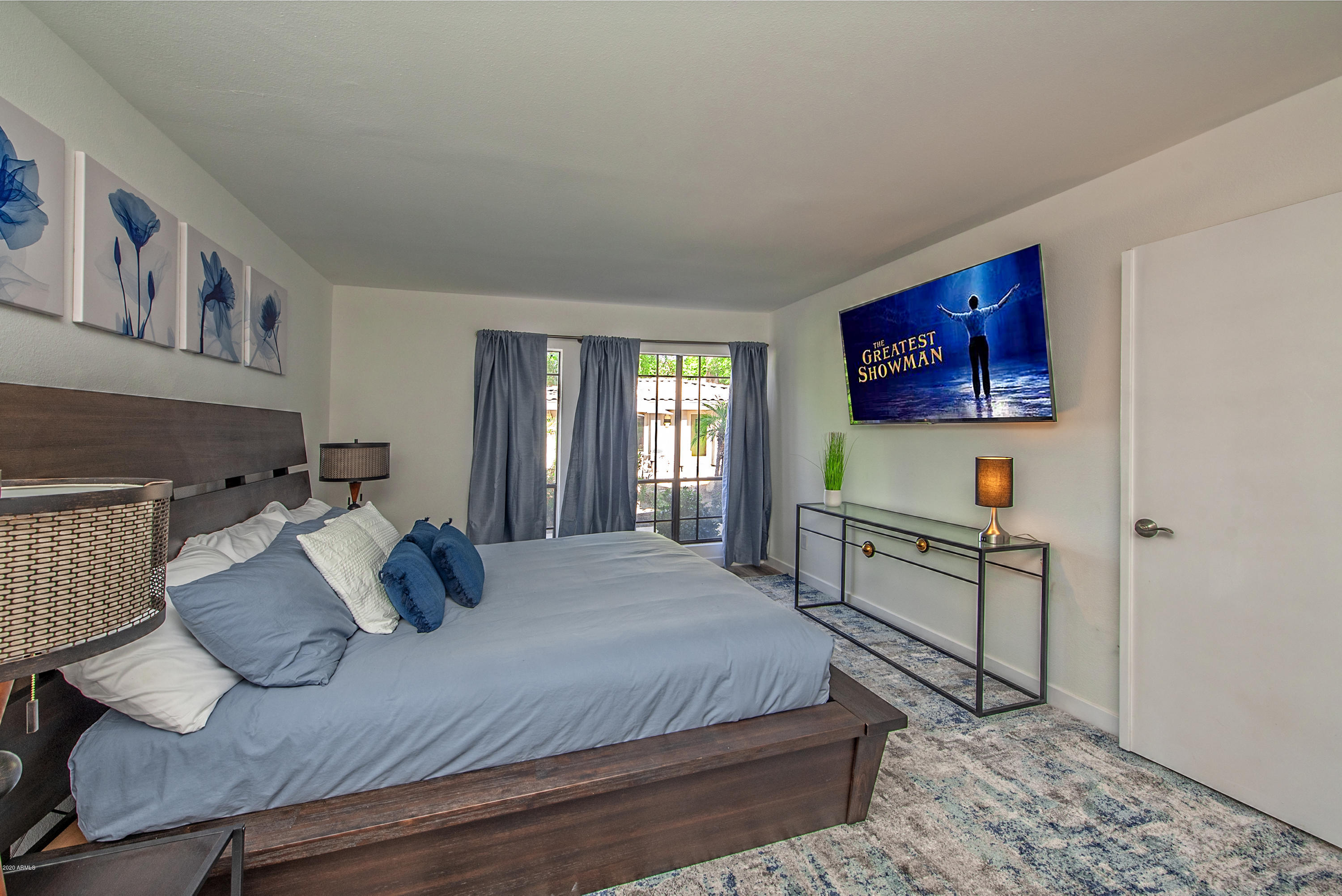 5209 North 24th Street, Unit 103 Phoenix, AZ 85016 - Photo 9 of 17 a bedroom with a bed and a flat screen tv