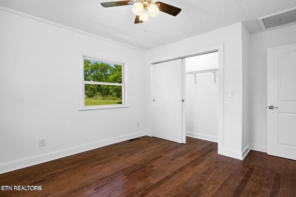 516 Delaware Avenue Oak Ridge, TN 37830 - Photo 33 of 43 an empty room with wooden floor chandelier fan and windows