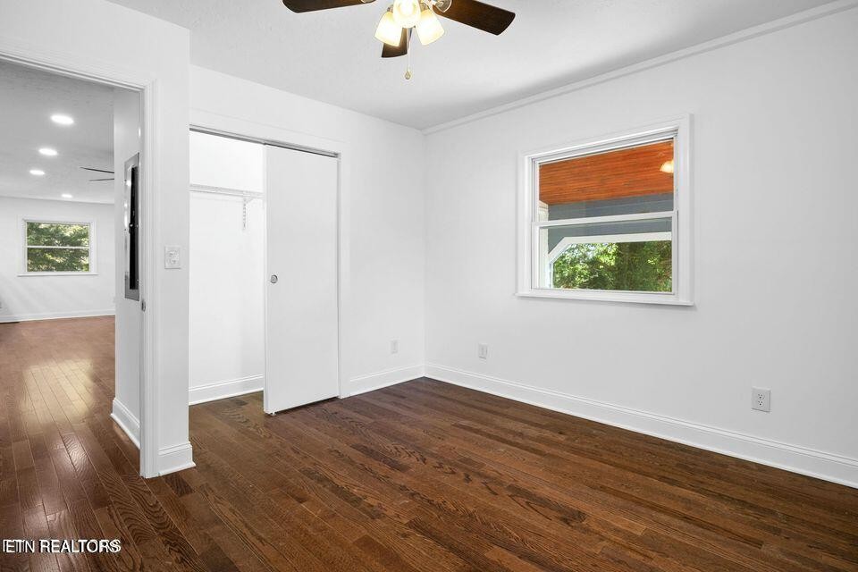 516 Delaware Avenue Oak Ridge, TN 37830 - Photo 35 of 43 an empty room with wooden floor chandelier fan and windows