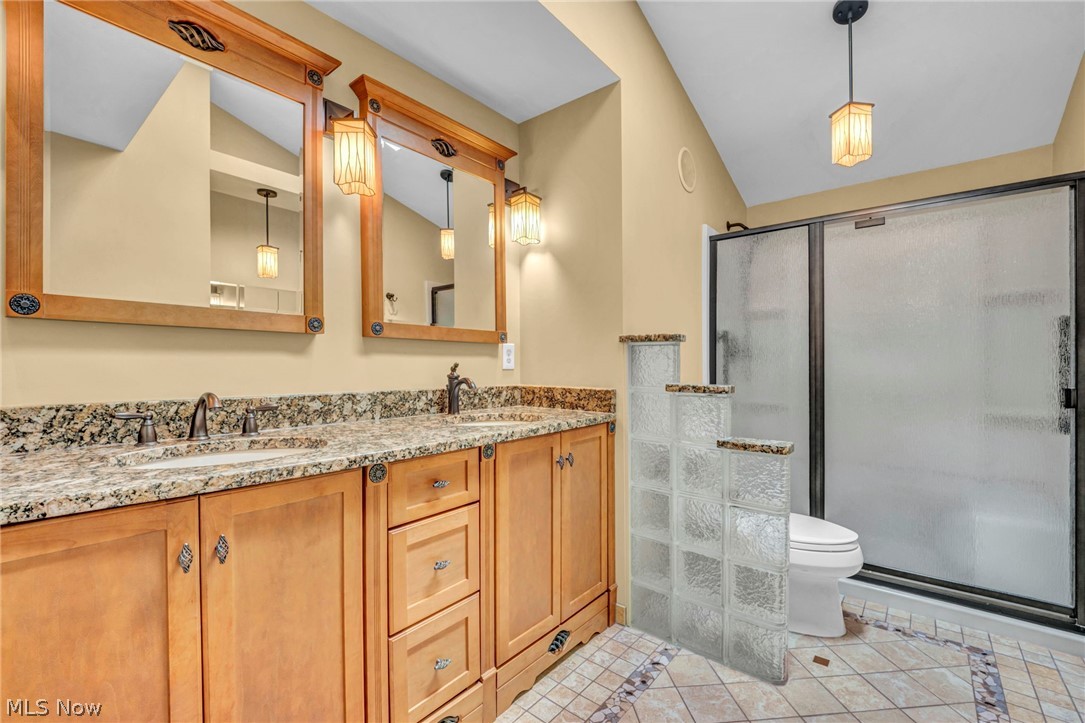 6845 Liberty Road Solon, OH 44139 - Photo 27 of 47 Double vanity with a stone countertop, individual framed mirrors, and dedicated wall sconces
