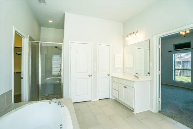 a bathroom with a tub sink and mirror