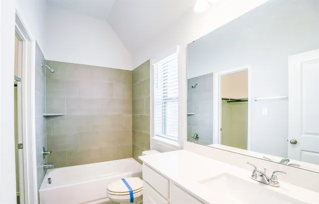 a bathroom with a granite countertop sink a toilet and shower