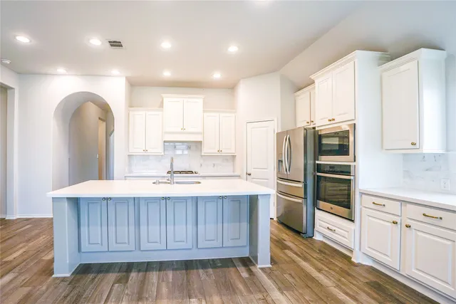 a kitchen with stainless steel appliances sink refrigerator and cabinets