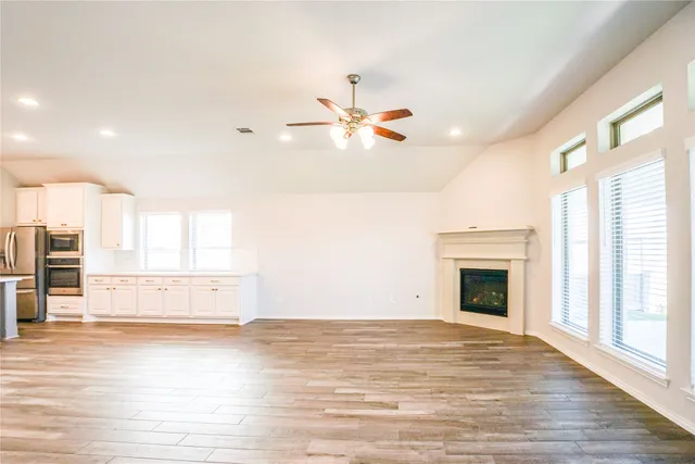 an empty room with a fireplace and wooden floor
