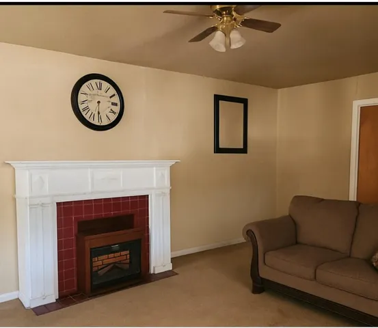 a living room with a couch a clock and a fireplace