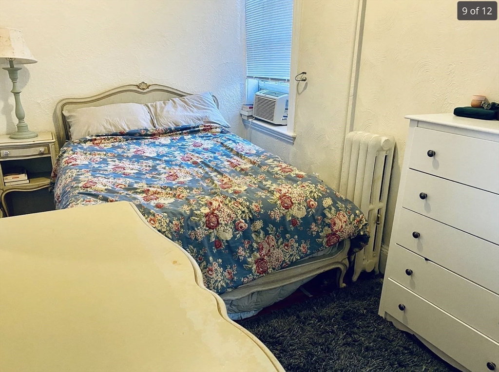 23 Temple Street, Unit 6 Boston, MA 02114 - Photo 5 of 10 a bed sitting in a bedroom next to a window with dresser