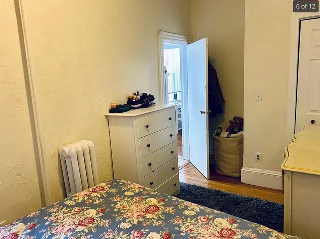 a bedroom with a dresser and wooden floor