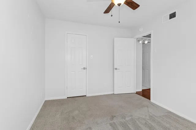 an empty room with chandelier fan