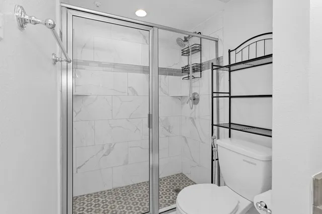 a bathroom with a shower toilet and sink