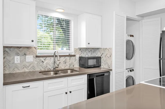 a kitchen with white cabinets and a fireplace
