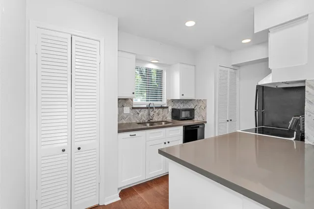 a kitchen with a refrigerator a sink and cabinets