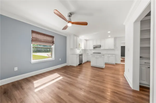 a kitchen with white cabinets stainless steel appliances and a window
