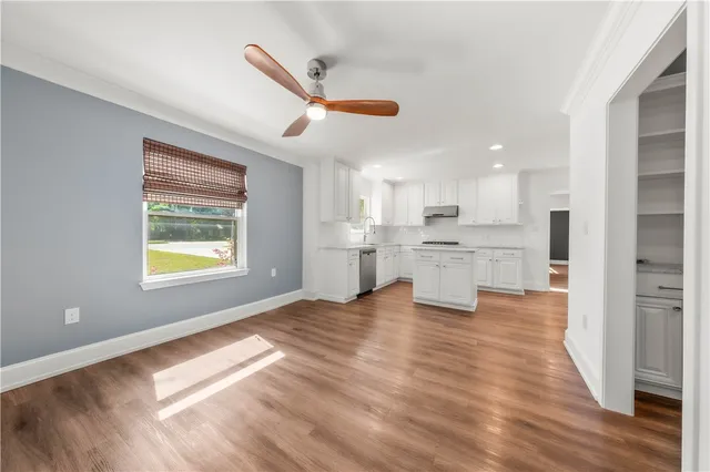 a kitchen with white cabinets stainless steel appliances and a window