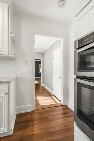 a view of a hallway with wooden floor and staircase