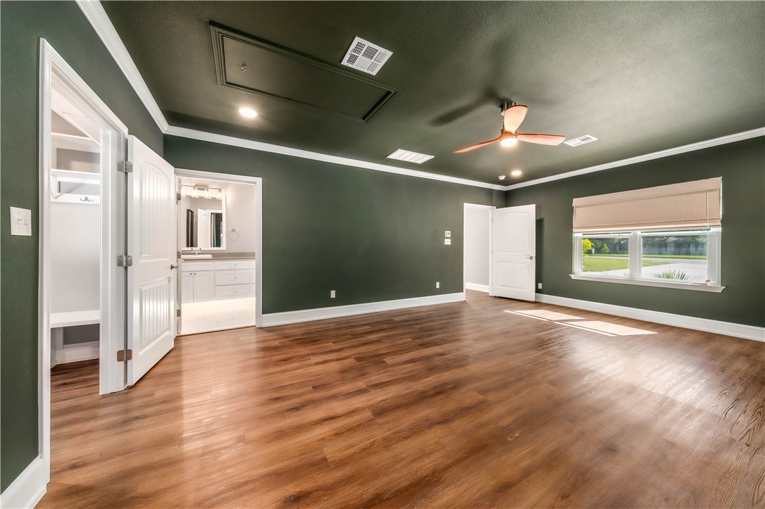 3405 MacArthur Drive Waco, TX 76708 - Photo 5 of 83 a view of an empty room with wooden floor and a kitchen