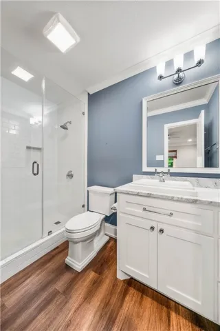 a view of a big room with wooden floor and a chandelier fan