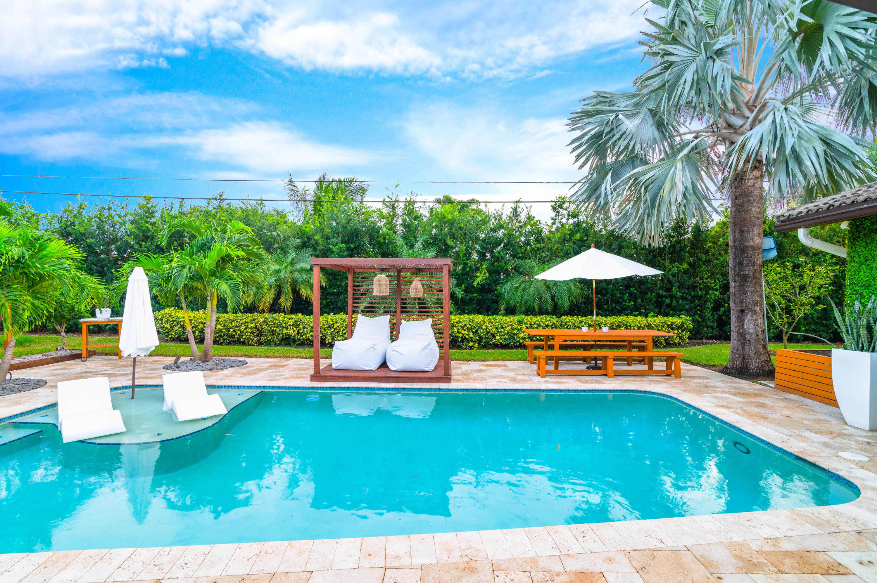 1502 Northwest 5th Street Boca Raton, FL 33486 - Photo 9 of 35 a view of a swimming pool with a table and chairs under an umbrella