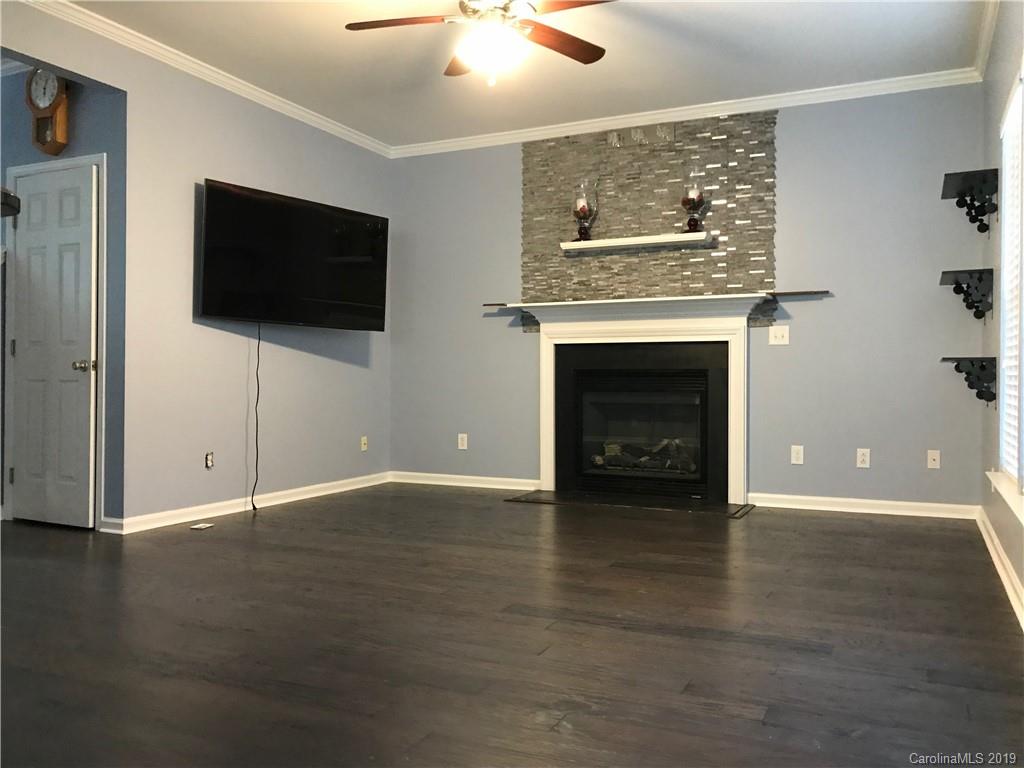 609 Eaton Court Fort Mill, SC 29708 - Photo 5 of 24 a view of an empty room with wooden floor and a fireplace