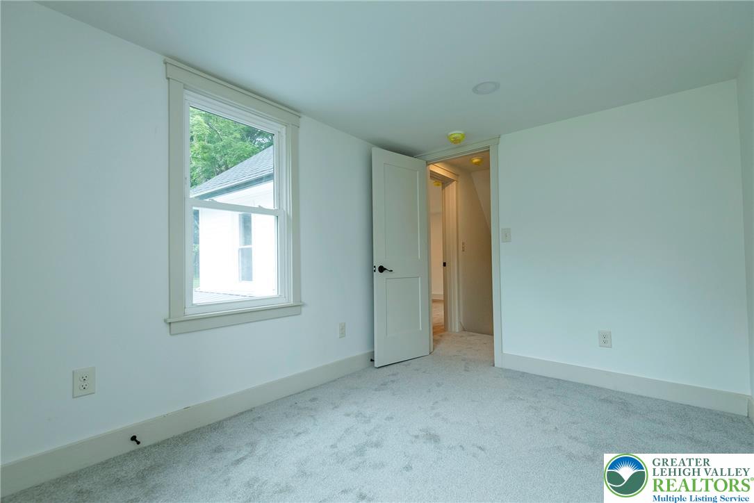 72 Allegheny Road Mount Bethel, PA 18343 - Photo 34 of 72 A well-lit bedroom features plush carpeting and a bright window overlooking verdant foliage.