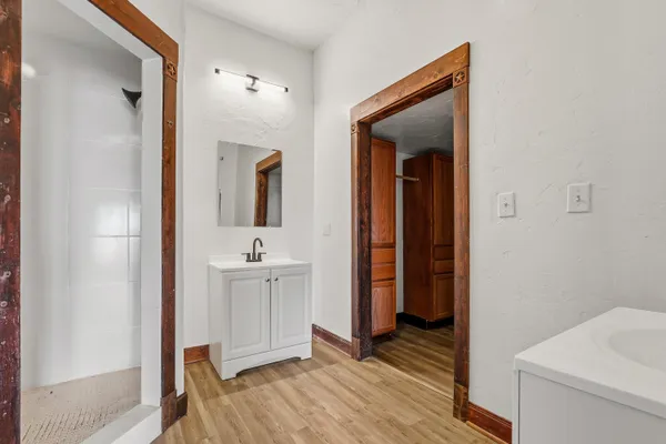 a large white kitchen with kitchen island white cabinets and stainless steel appliances