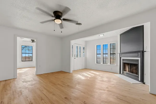 an empty room with a window and a ceiling fan