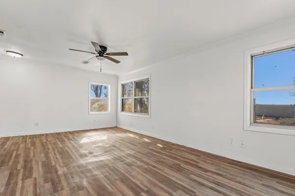 a view of a big room with wooden floor and windows
