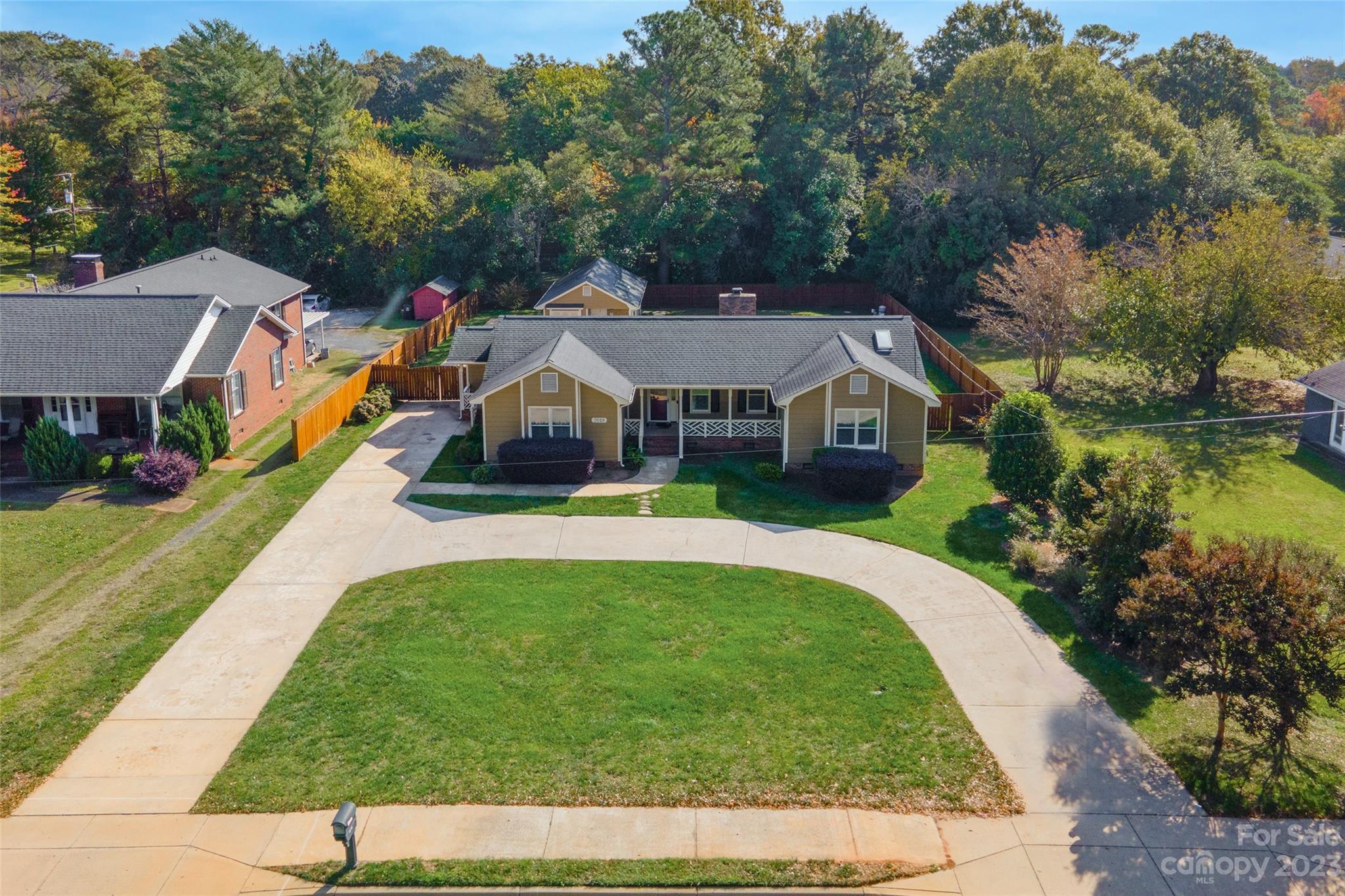 a view of house with garden and tall trees