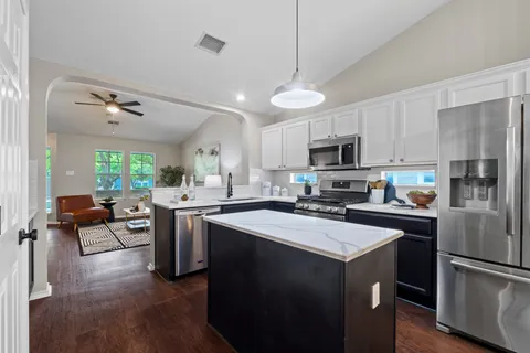 a kitchen with a center island stainless steel appliances and cabinets