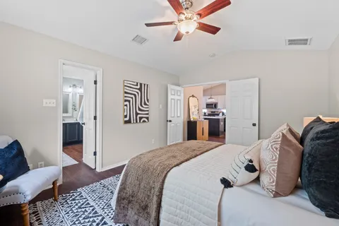 a bedroom with a large bed and ceiling fan