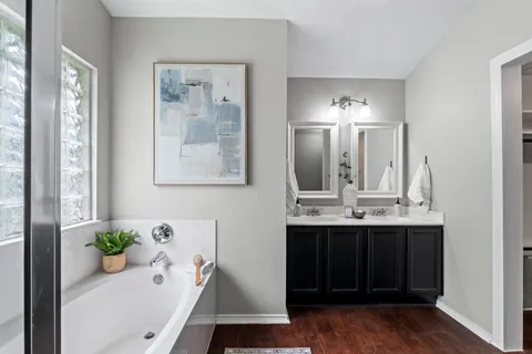 a bathroom with a tub sink and mirror