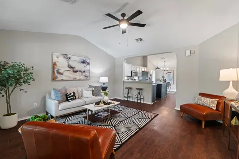 a living room with furniture and wooden floor