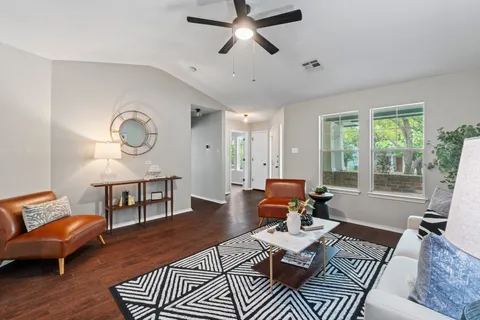 a living room with furniture a rug and a large window