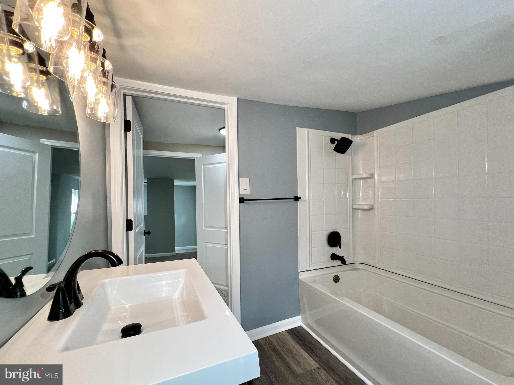 516 10th Avenue Lindenwold, NJ 08021 - Photo 17 of 22 a bathroom with a tub a sink and mirror