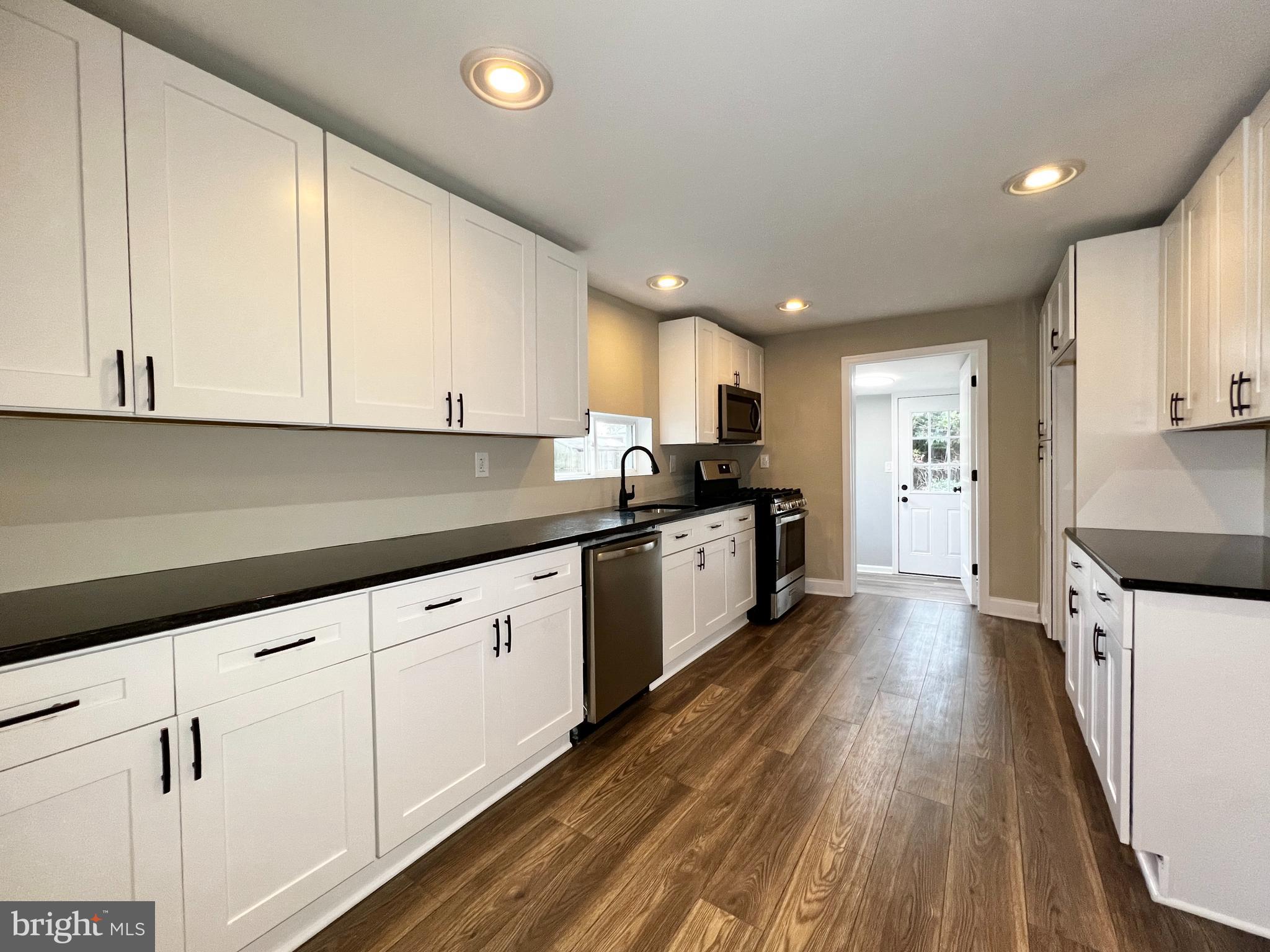 516 10th Avenue Lindenwold, NJ 08021 - Photo 6 of 22 a large kitchen with stainless steel appliances granite countertop a stove a sink and white cabinets