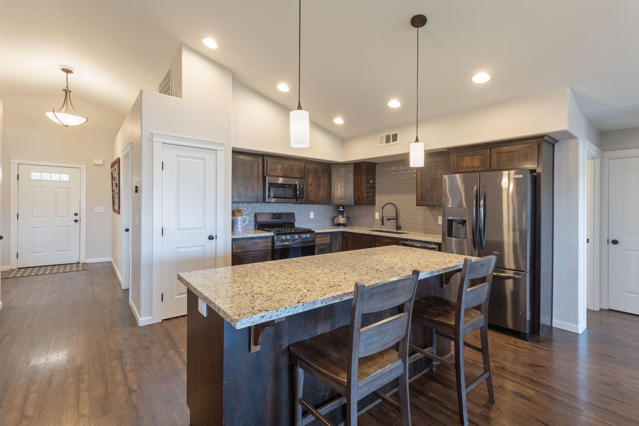 110 Linton Way Eagle Point, OR 97524 - Photo 3 of 41 a kitchen with stainless steel appliances granite countertop a refrigerator a sink dishwasher a stove and a dining table with wooden floor