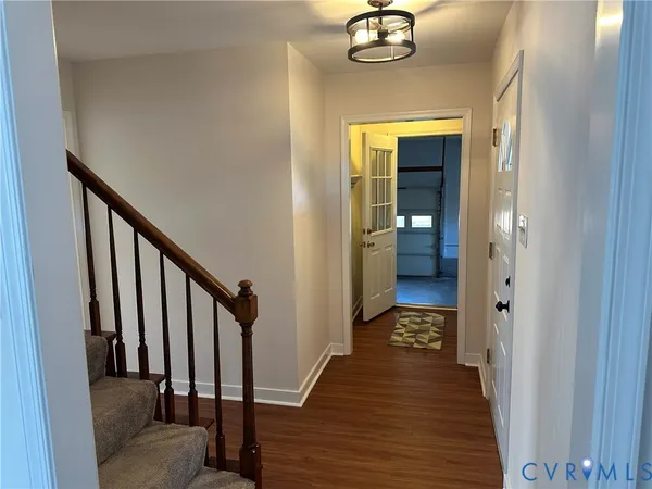 a view of a hallway with wooden floor and staircase