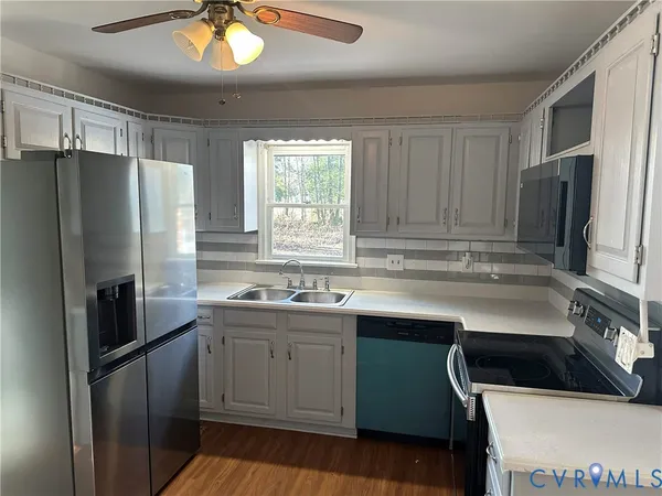 a kitchen with a sink a refrigerator and cabinets