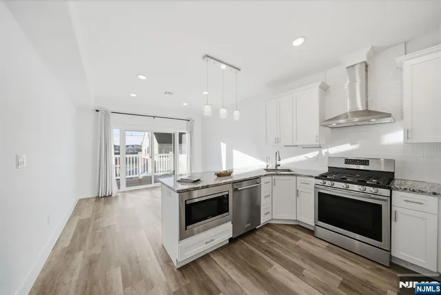 a kitchen with stainless steel appliances granite countertop a stove and a sink