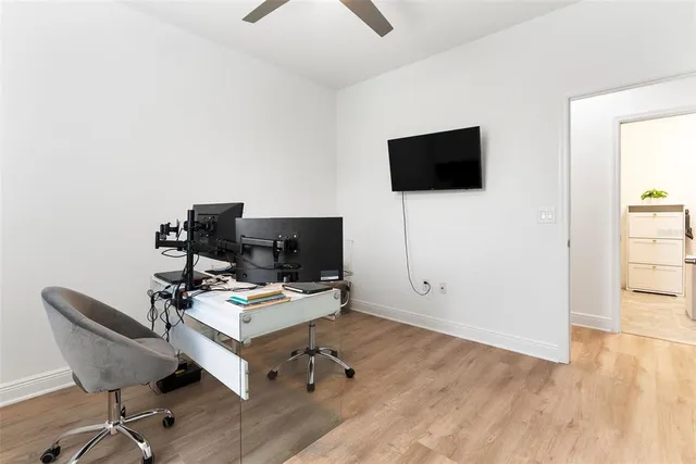 a view of a workspace with furniture and a window