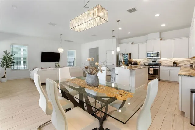 a kitchen with kitchen island a dining table and chairs