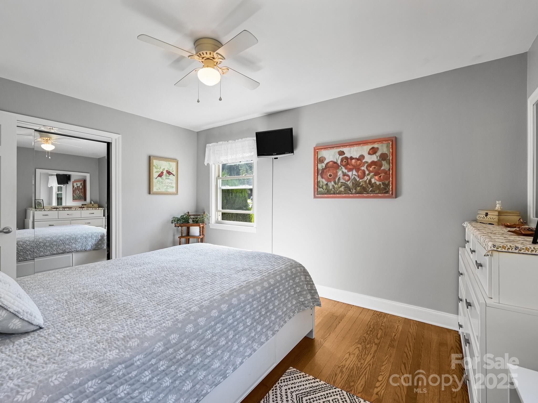 402 Balsam Road Hendersonville, NC 28792 - Photo 12 of 26 a bedroom with a bed and a chandelier