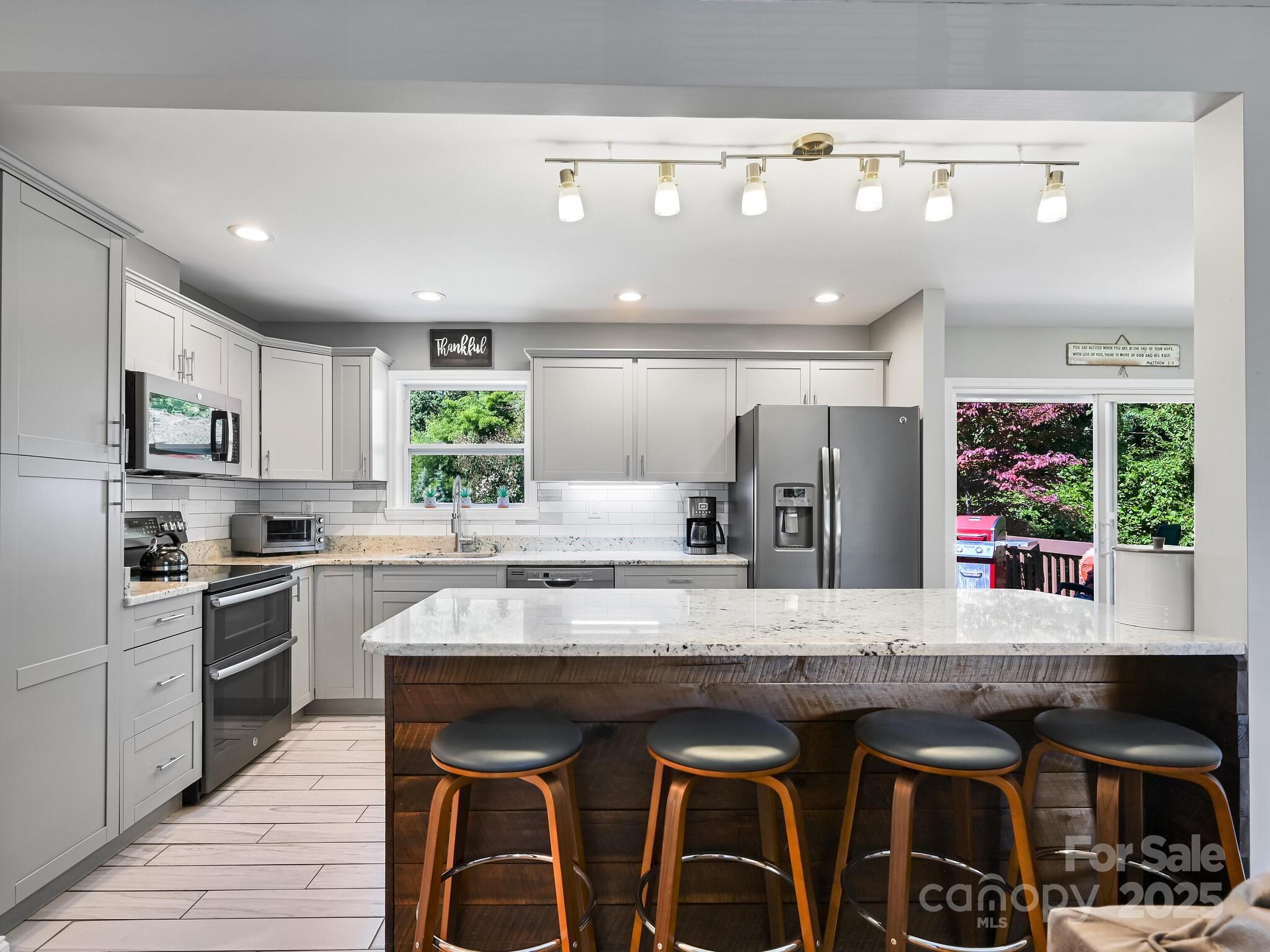 402 Balsam Road Hendersonville, NC 28792 - Photo 13 of 26 a kitchen with granite countertop a center island and stainless steel appliances