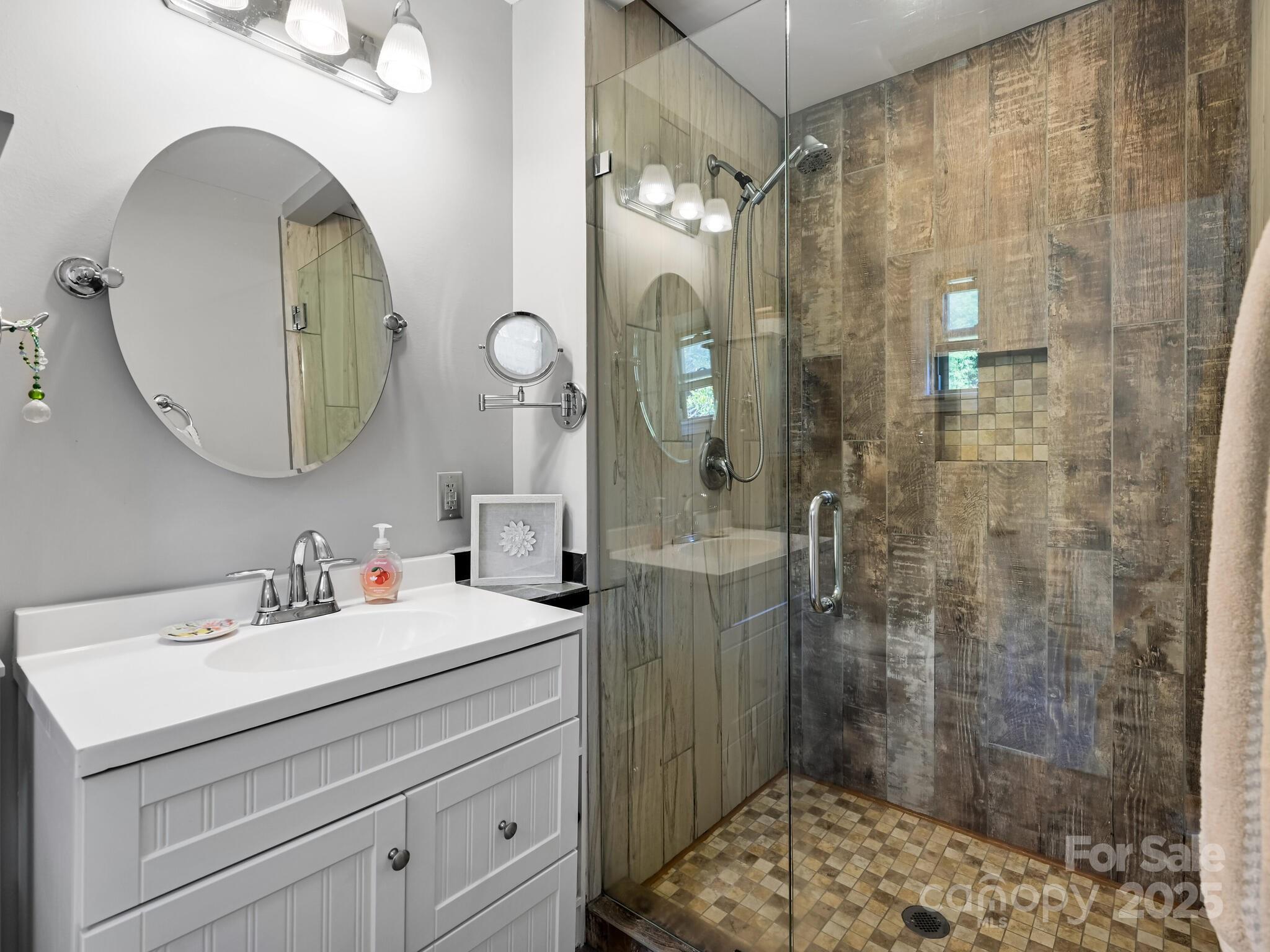 402 Balsam Road Hendersonville, NC 28792 - Photo 22 of 26 a bathroom with a sink mirror and a shower