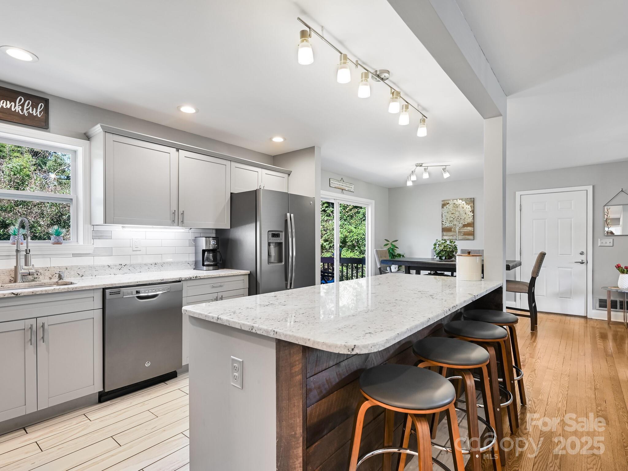 402 Balsam Road Hendersonville, NC 28792 - Photo 5 of 26 a kitchen with stainless steel appliances granite countertop a kitchen island a stove a table and chairs