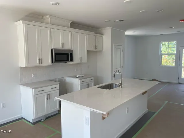 a kitchen with a sink a microwave and cabinets