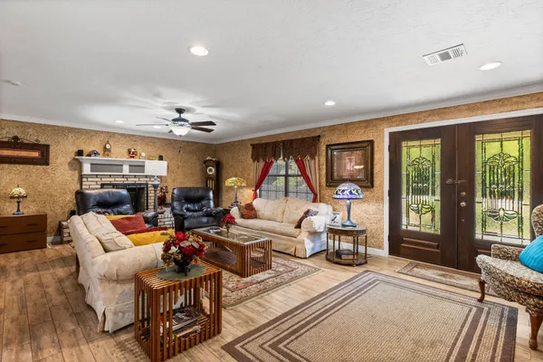 a living room with furniture a large window and a chandelier