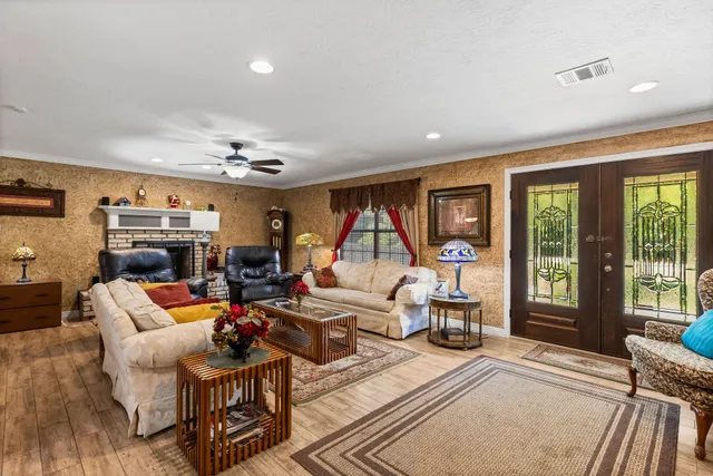 a living room with furniture a large window and a chandelier