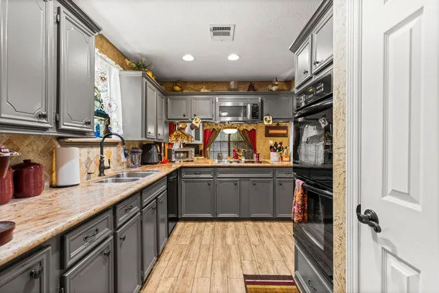 a kitchen with stainless steel appliances granite countertop a sink and cabinets